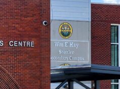 Wm. E. Hay & Stettler Elementary Remain Open Under RCMP Presence Exterior view of a brick Arts Centre building with a round school logo and sign reading 'Wm. Hay Stettler Secondary Campus' (front entrance area).