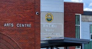 Wm. E. Hay & Stettler Elementary Remain Open Under RCMP Presence Exterior view of a brick Arts Centre building with a round school logo and sign reading 'Wm. Hay Stettler Secondary Campus' (front entrance area).