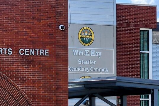Wm. E. Hay & Stettler Elementary Remain Open Under RCMP Presence Exterior view of a brick Arts Centre building with a round school logo and sign reading 'Wm. Hay Stettler Secondary Campus' (front entrance area).