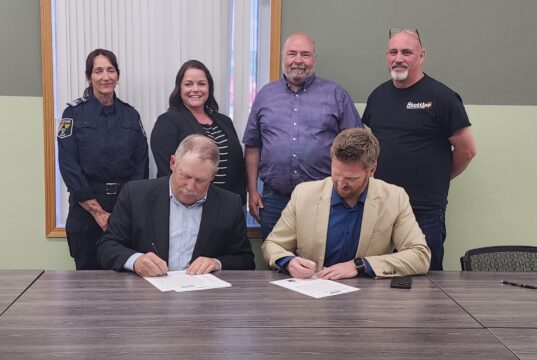 Town of Stettler & County of Stettler Declare May 25-29 As Alberta Rural Health Week Two men seated at a long table sign documents while four colleagues stand behind them in a meeting room.