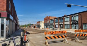 Stettler Residents Encouraged To Visit Businesses Impacted By Construction Street under construction with orange barriers reading 'ROAD CLOSED' and a closed curbside area on a sunny day in a commercial district.