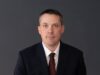Drumheller-Stettler UCP MLA Nate Horner Not Seeking Re-Election Professional headshot of a man in a navy suit and burgundy tie against a dark gray background.