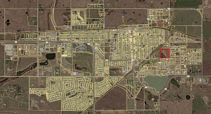 A satellite map of a grid-pattern town with numerous streets; a red square marks a specific block in the eastern central area.