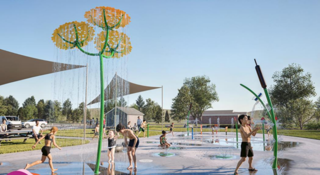 Children playing on a splash pad with yellow flower water jets under a blue sky.