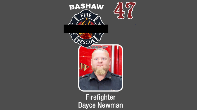 Portrait of a firefighter in uniform beneath a fire department badge, with a gray background and the word 'Firefighter' shown below.