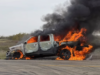 Heartland Regional Fire Extinguishes Highway 835 Vehicle Blaze A burned pickup truck on a rural road engulfed in bright orange flames with thick black smoke.