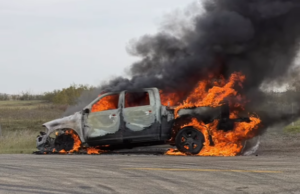 Heartland Regional Fire Extinguishes Highway 835 Vehicle Blaze A burned pickup truck on a rural road engulfed in bright orange flames with thick black smoke.
