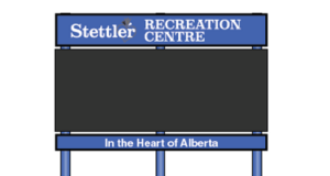 Town of Stettler Awards $68K Contract For New Recreation Centre Digital Sign Outdoor sign for Stettler Recreation Centre, with a blue header and posts, showing the slogan 'In the Heart of Alberta' on a wooden fence backdrop.