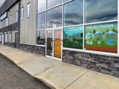 Stettler County Recommends Higher Fire Response Fees For Heartland Commission Commercial storefront with large glass windows displaying 'FIRE PREVENTION' posters and safety graphics outside a building exterior.