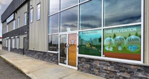 Stettler County Seeks Higher Cost Recovery Under New Regional Fire Commission Commercial storefront with large glass windows displaying 'FIRE PREVENTION' posters and safety graphics outside a building exterior.