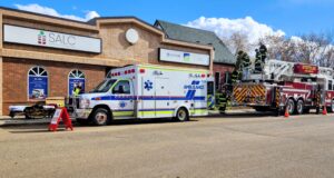 Area Youth Get Hands-On Experience at Stettler Skills Day Emergency response scene outside the SALC building with an ambulance and a ladder fire truck as firefighters work on site nearby.