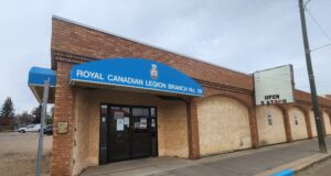 Stettler Legion Requests Town Council Grant Writing Help For Roof, HVAC Repairs Brick building storefront with a blue curved sign reading 'ROYAL CANADIAN LEGION BRANCH No. 59' above the entrance.