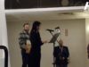 Stettler Awards Gala Celebrates Local Citizens & Businesses Woman speaks at a microphone at a podium on a stage; a man in plaid stands with award plaques behind her, festive balloons to the right.