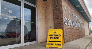 How to Vote In The 2026 Alberta Referendum Exterior view of a brick community hall with a bright yellow