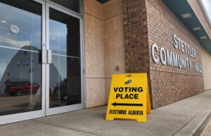 How to Vote In The 2026 Alberta Referendum Exterior view of a brick community hall with a bright yellow